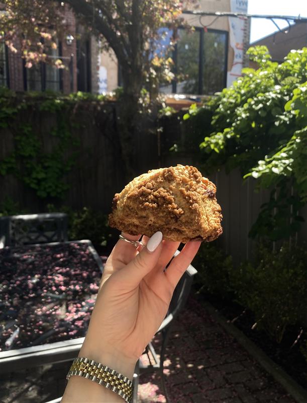 A cinnamon streusel scone being held