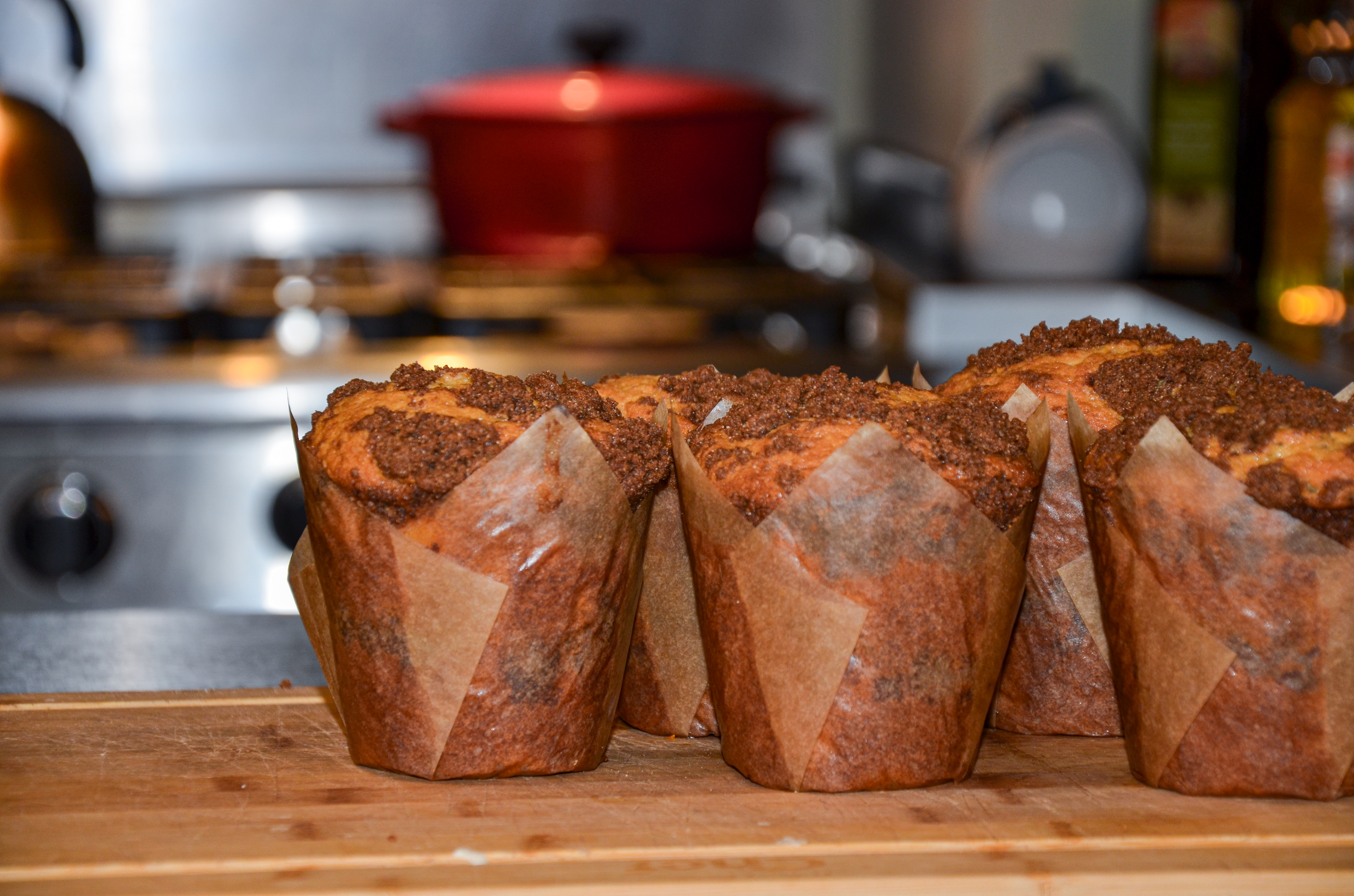 Large coffee cake muffins on a wood cuttingboard
