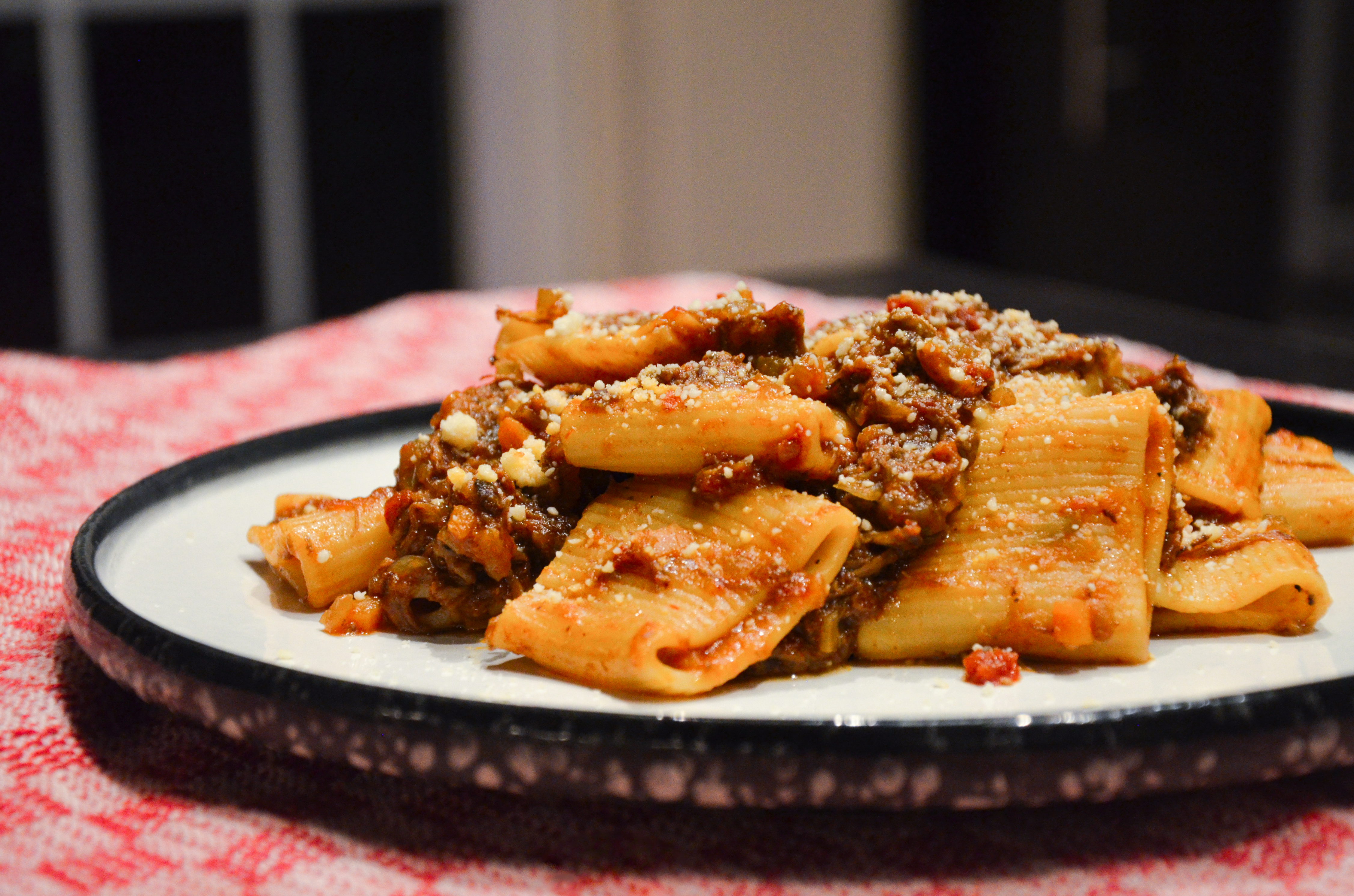 Braised Beef Short Rib Ragu with Paccheri Rigati Pasta on a decorative plate